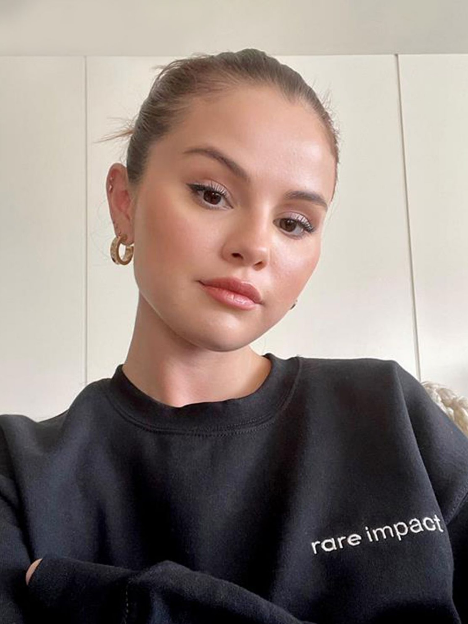 Selena Gomez wearing a Rare Impact sweatshirt