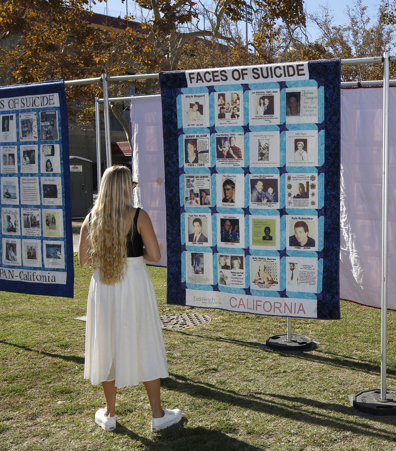 A photo of a woman looking at a Didi Hirsch poster