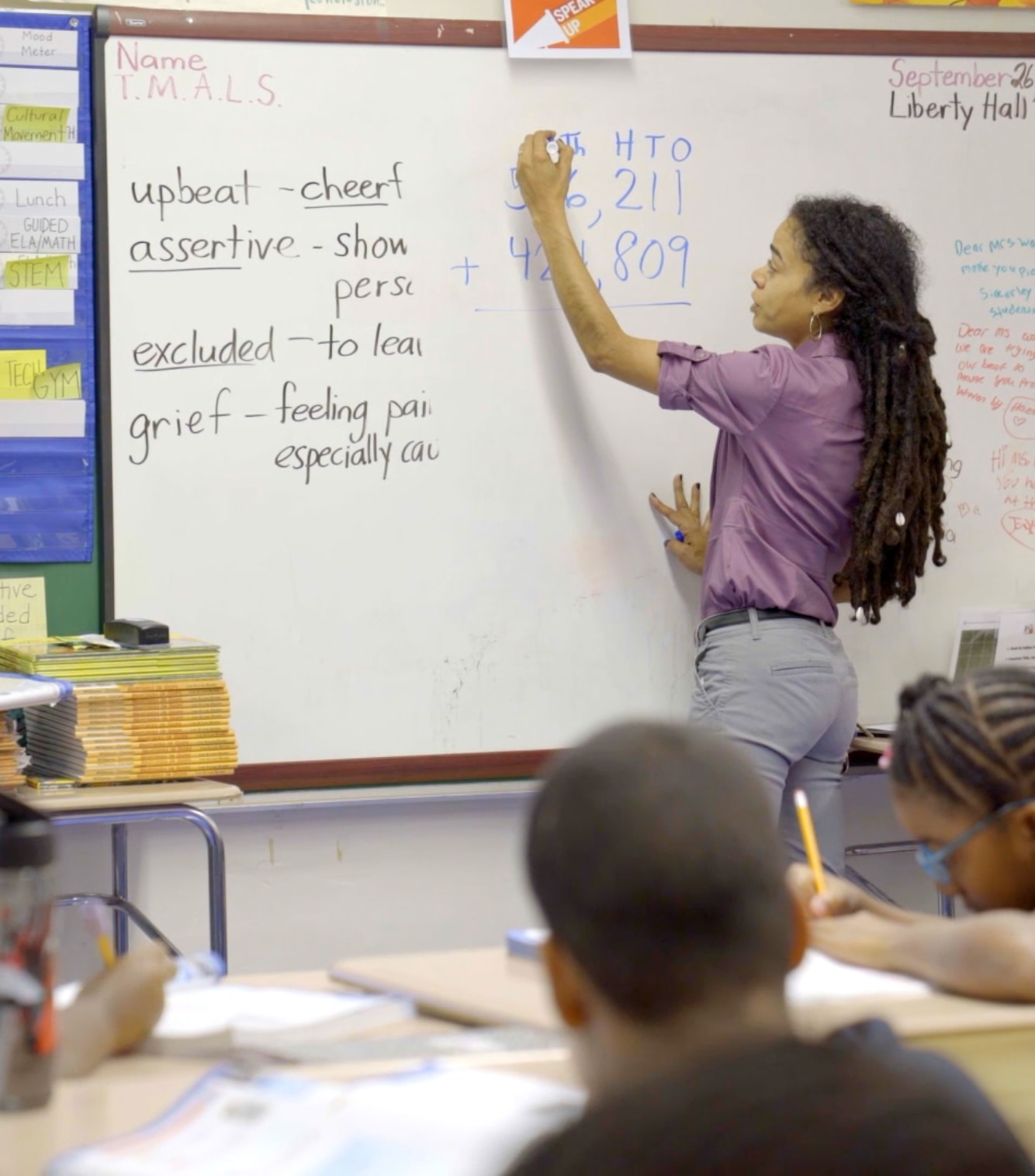 Photo of a teacher writing on a white board